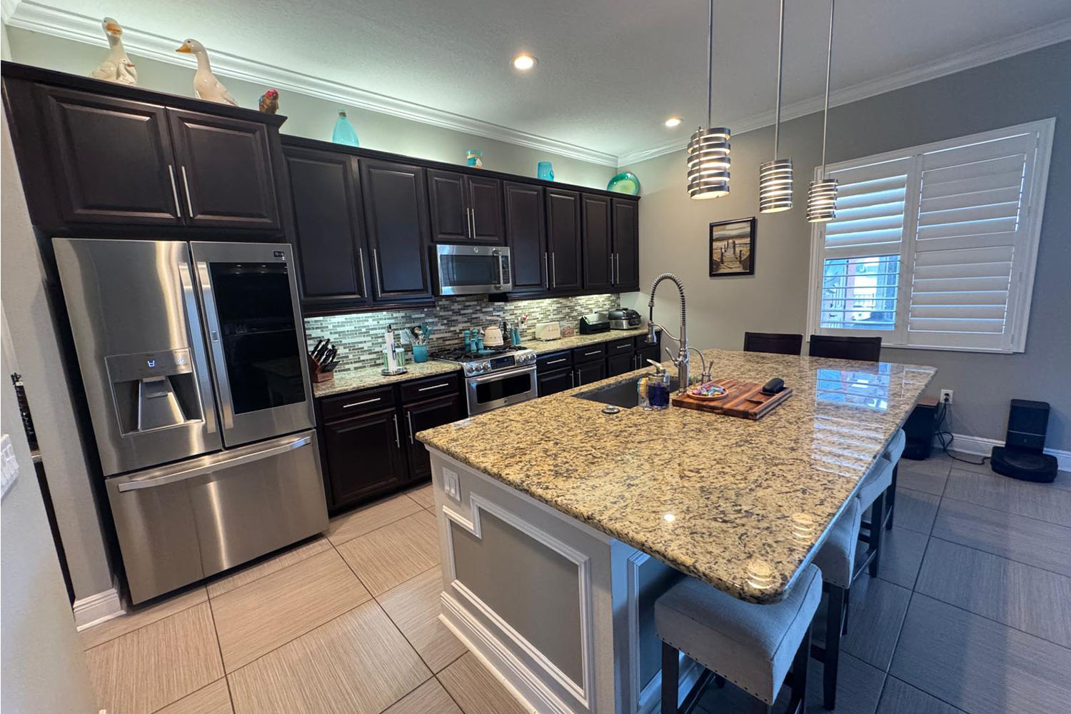 Back of a man at a concert. Hes wearing a beanie hat and a baggy denim jacket with studs. Photo with a purple hue